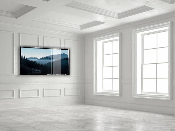 A 75-inch TV wall-mounted in a bright white living room with classical molding, placed by AI