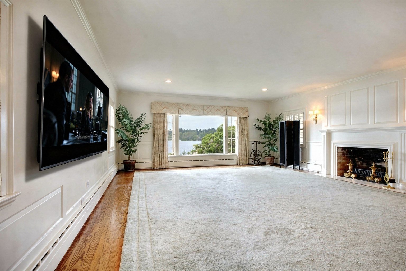 A 75-inch TV flat-mounted on the left wall of an elegant living room with wainscoting and a brick fireplace, placed by AI from a single photo